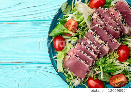 Salad with raw tuna , sesame and cherry tomatoes photography . Top view 120390994