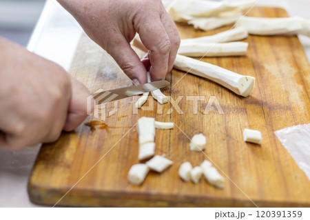 senior woman hand cut horseradish on wooden cutting board senior woman hand cut horseradish on wooden cutting board 120391359