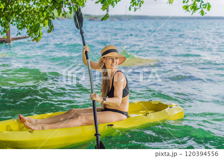 Woman kayaking on Bacalar Lake in Mexico. Adventure tourism in Quintana Roo, outdoor exploration, and water activities concept 120394556