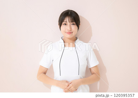 エステや美容ナースなど受付のポーズ　ピンク背景のカメラ目線 120395357
