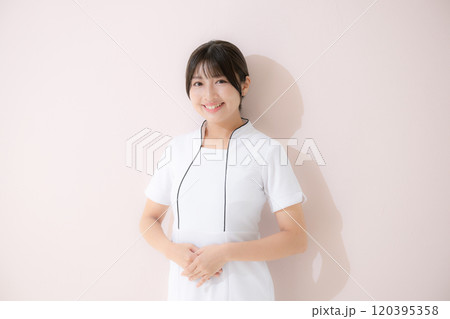 エステや美容ナースなど受付のポーズ　ピンク背景のカメラ目線 120395358