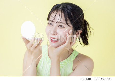 夏イメージ 黄色バック 鏡を見ている若い女性 夏イメージ 黄色バック 鏡を見ている若い女性 120397281