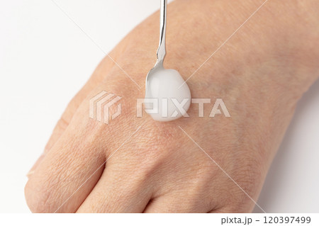 スパチュラで保湿クリームを取り手の甲に乗せる 120397499