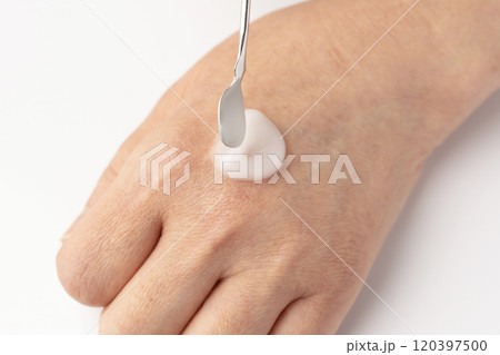 スパチュラで保湿クリームを取り手の甲に乗せる 120397500