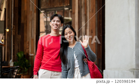 A lovely Asian couple enjoying a weekend date as they stroll through the city and shop together. 120398194
