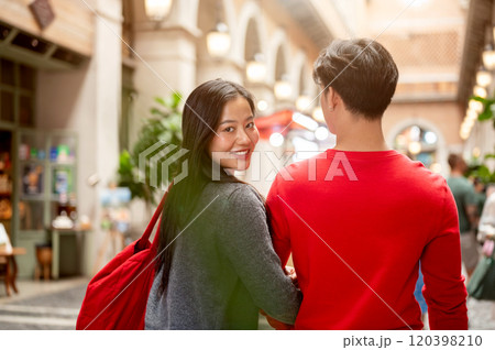 A beautiful young Asian woman enjoys shopping with her boyfriend at a mall on Christmas. A beautiful young Asian woman enjoys shopping with her boyfriend at a mall on Christmas. 120398210
