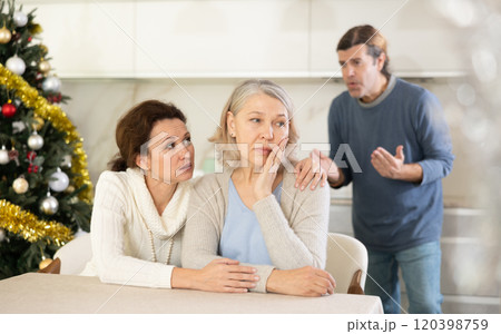 Woman sits near elderly mother and comforts during quarrel with son on New Year eve Woman sits near elderly mother and comforts during quarrel with son on New Year eve 120398759