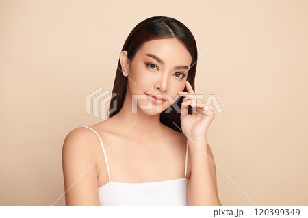 Beautiful young asian woman with clean fresh skin on beige background, Face care, Facial treatment, Cosmetology, beauty and spa, Asian women portrait. 120399349