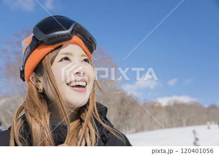 雪の降るスキー場で笑顔で立つスノボ女子 120401056