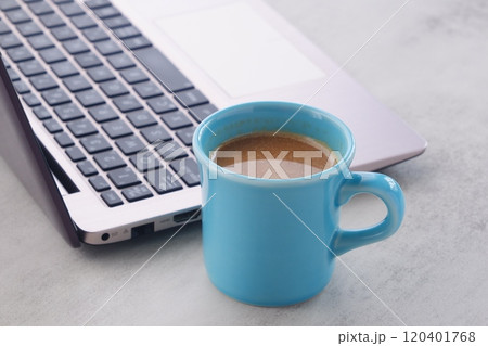 オフィスでデスクワークの合間に、牛乳をたっぷり入れたコーヒーのカフェ・ラッテを飲む オフィスでデスクワークの合間に、牛乳をたっぷり入れたコーヒーのカフェ・ラッテを飲む 120401768