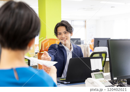 資料を渡すビジネスマン 資料を渡すビジネスマン 120402021