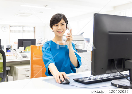 オフィスで電話に出る女性 120402025