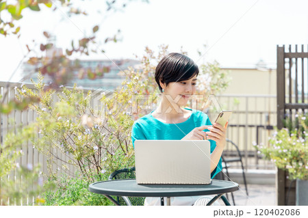 テラスでテレワークをする女性 120402086