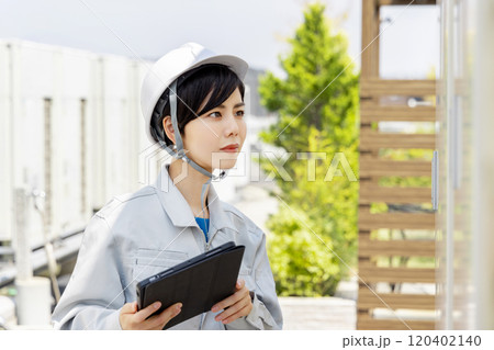 変電設備を点検する女性作業員 120402140