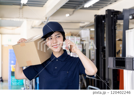 物流・運送業界　スマートフォンで連絡をする女性 120402246
