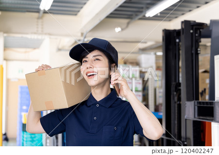 物流・運送業界　スマートフォンで連絡をする女性 120402247