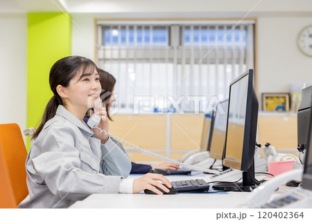 オフィスで電話に出る女性 オフィスで電話に出る女性 120402364