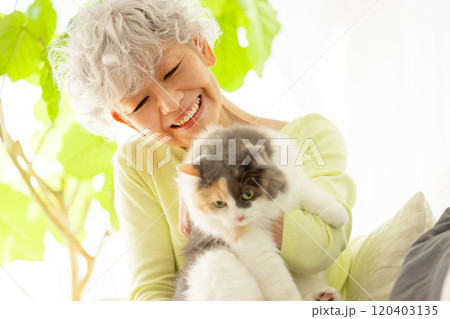 猫を抱っこする日本人シニア女性 120403135
