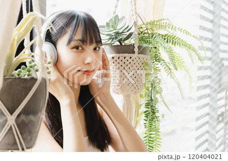 窓辺で音楽を聴く若い女性 窓辺で音楽を聴く若い女性 120404021