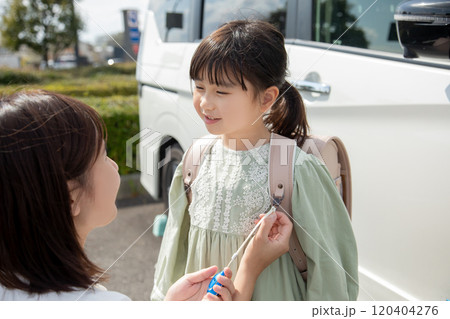 防犯ブザーを付ける母親 防犯ブザーを付ける母親 120404276