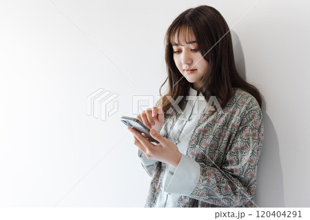 スマホを操作するハーフの若い女性 120404291