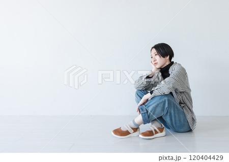 体育座りをする若い女性 120404429