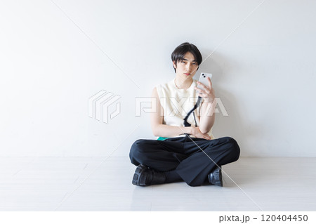 スマホを使う奇抜な服装の男性 120404450