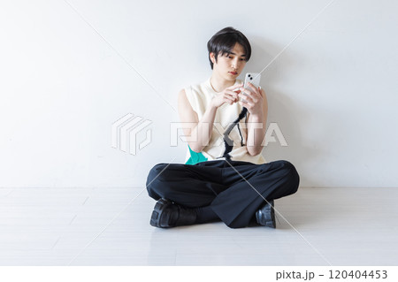 スマホを使う奇抜な服装の男性 120404453