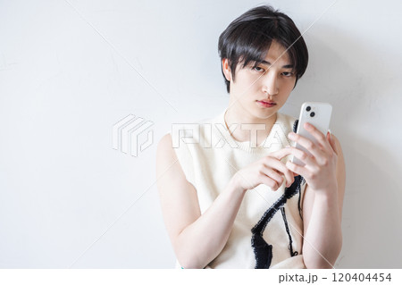 スマホを使う奇抜な服装の男性 120404454