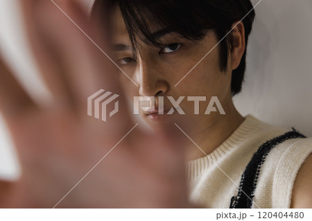 指の間から●●を空かしてみる若い男性 指の間から●●を空かしてみる若い男性 120404480