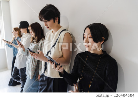 スマートフォンを使うZ世代の男女 スマートフォンを使うZ世代の男女 120404504