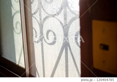 昭和を連想させる窓ガラスと屋外の鉄格子の影と昭和スイッチ 120404785