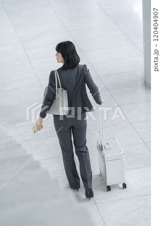 キャリーバッグを引いて歩くミドルのビジネスウーマン　後ろ姿 120404907