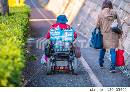 日本の横浜都市景観　危険が潜む下り坂の狭い歩道…段差、傾き、空き缶…高齢化社会、電動車椅子の高齢女性 120405402