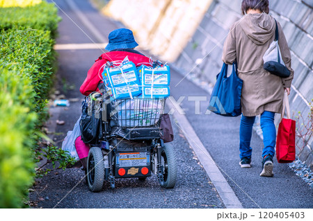 日本の横浜都市景観　危険が潜む下り坂の狭い歩道…段差、傾き、空き缶…高齢化社会、電動車椅子の高齢女性 120405403