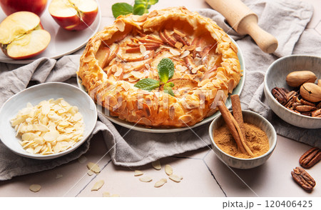 Delicious homemade apple galette decorated with almond flakes and fresh mint Delicious homemade apple galette decorated with almond flakes and fresh mint 120406425