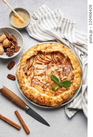 Delicious homemade apple galette decorated with almond flakes and fresh mint Delicious homemade apple galette decorated with almond flakes and fresh mint 120406426