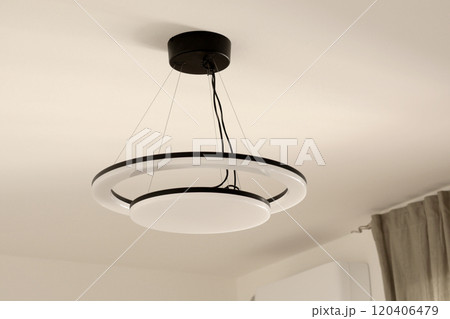 LED white bulb black wires on ceiling in room. Lighting and energy saving. Modern minimalist design. LED white bulb black wires on ceiling in room. Lighting and energy saving. Modern minimalist design. 120406479