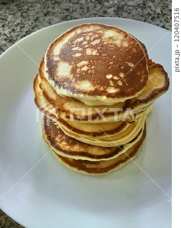 Stack of pancakes on white plate at the table 120407516