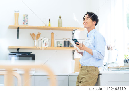 ダイニングでコーヒーを飲む男性 120408310