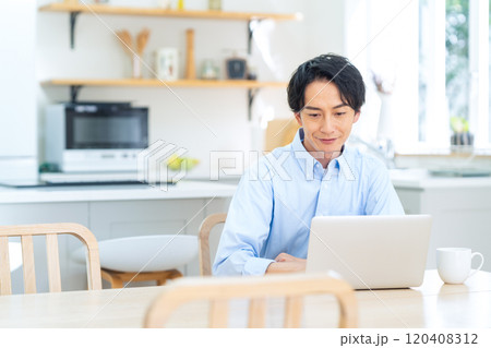 リビングでテレワークをする若い男性 リビングでテレワークをする若い男性 120408312