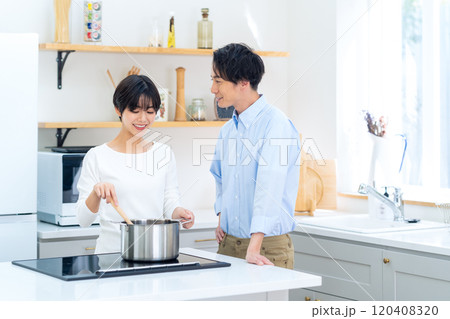 キッチンで料理をする若い夫婦 キッチンで料理をする若い夫婦 120408320