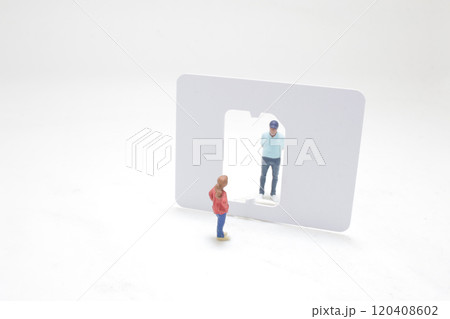 Miniature Figures Interacting Through Sim Card Cutout Miniature Figures Interacting Through Sim Card Cutout 120408602
