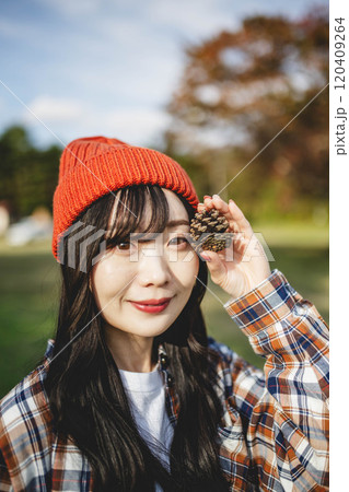 松ぼっくりを持っている女性 120409264