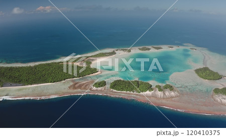 Aerial drone view of Rangiroa atoll showing the turquoise lagoon, coral reefs, and forested motus, typical of the tuamotu archipelago in French Polynesia. Remote wild nature exotic travel background 120410375