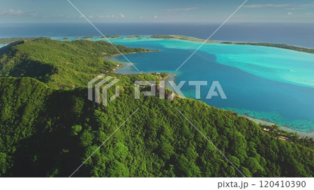 Tropical green mountain Bora Bora island, aerial view. Drone fly over forest coastline with turquoise water, showcasing beauty and tranquility of exotic wild nature. Summer luxury travel background Tropical green mountain Bora Bora island, aerial view. Drone fly over forest coastline with turquoise water, showcasing beauty and tranquility of exotic wild nature. Summer luxury travel background 120410390