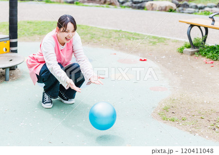 ボールで子供と遊ぶ保育士 ボールで子供と遊ぶ保育士 120411048