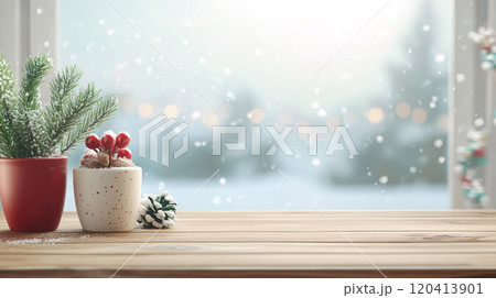 Empty wooden desk on scenic snowy winter outside a window with cute holly in pot plants. Suit for Christmas and New Year seasonal. Warm color tone. AI generated. 120413901