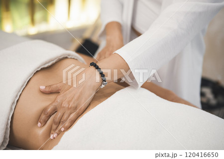 Massage process of the abdomen and peritoneal organs in pro salon, close-up. Therapist hand on female body, faceless people, movement, selective focus. Massage process of the abdomen and peritoneal organs in pro salon, close-up. Therapist hand on female body, faceless people, movement, selective focus. 120416650