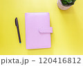 Pink Leather Planner with Pen and Plant on Yellow Background 120416812